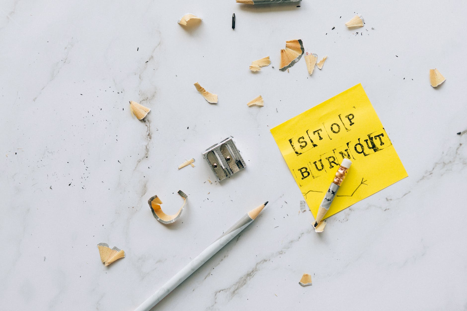 close up photo of sharpener and pencil on marble surface